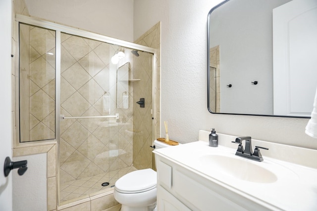 full bath featuring a stall shower, toilet, a textured wall, and vanity