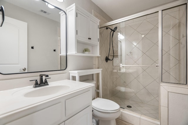 full bathroom featuring toilet, visible vents, a shower stall, and vanity