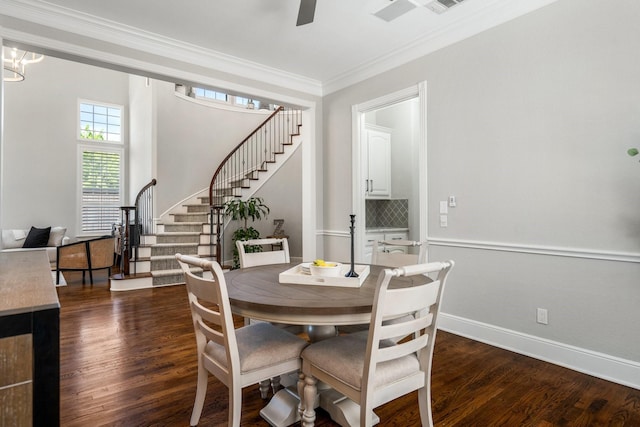 dining room featuring dark wood-style floors, ceiling fan, crown molding, stairs, and baseboards