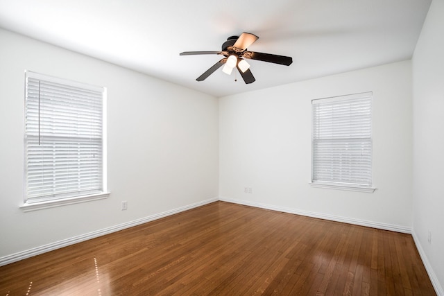 spare room featuring baseboards, hardwood / wood-style flooring, and ceiling fan