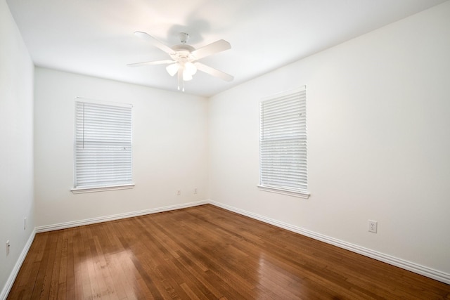 empty room featuring ceiling fan, hardwood / wood-style floors, and baseboards
