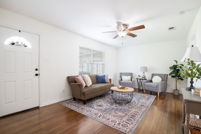 living room featuring visible vents, hardwood / wood-style flooring, a ceiling fan, and baseboards