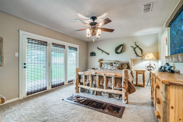 bedroom featuring access to exterior, visible vents, carpet, baseboards, and a textured ceiling
