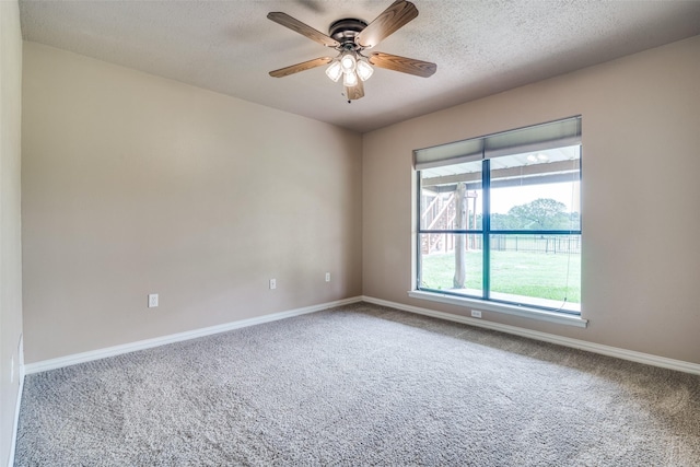 unfurnished room with carpet flooring, ceiling fan, and baseboards