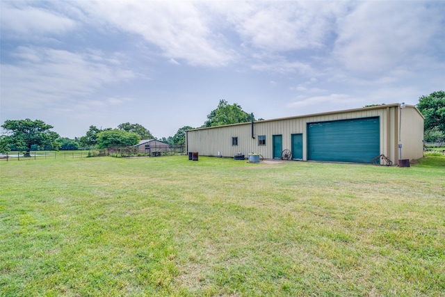 view of yard featuring an outbuilding, a detached garage, and fence