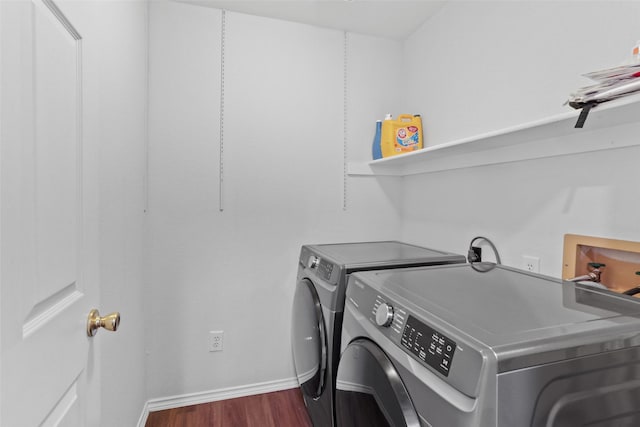 laundry area with dark wood-style flooring, washer and dryer, laundry area, and baseboards