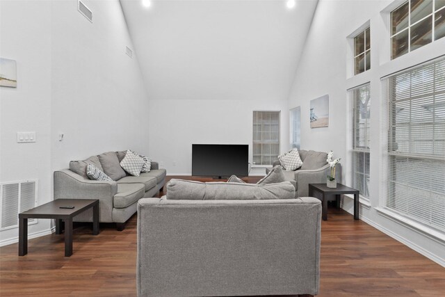 living room with dark wood-style floors, visible vents, recessed lighting, and high vaulted ceiling