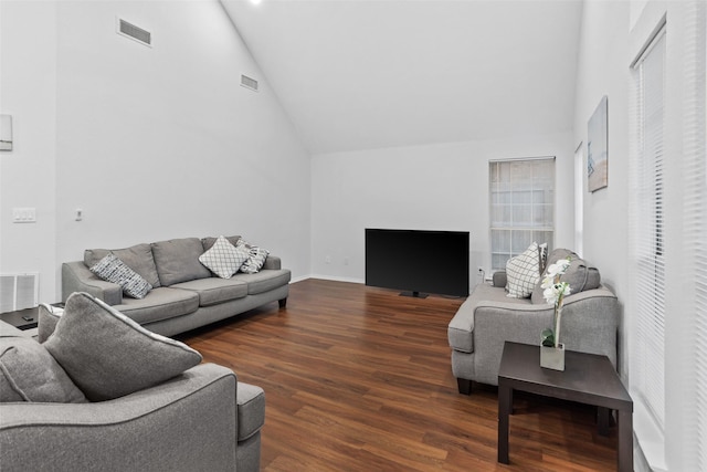 living area featuring wood finished floors, visible vents, and high vaulted ceiling