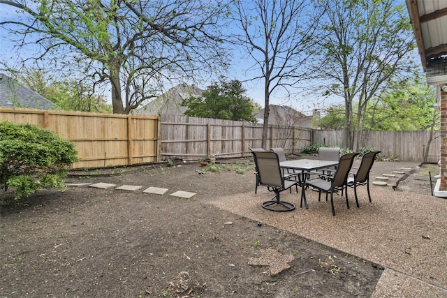 view of yard featuring outdoor dining area and a fenced backyard