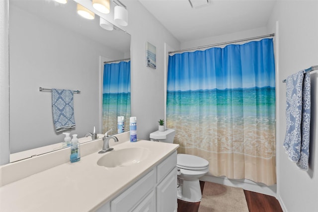 bathroom with toilet, wood finished floors, and vanity