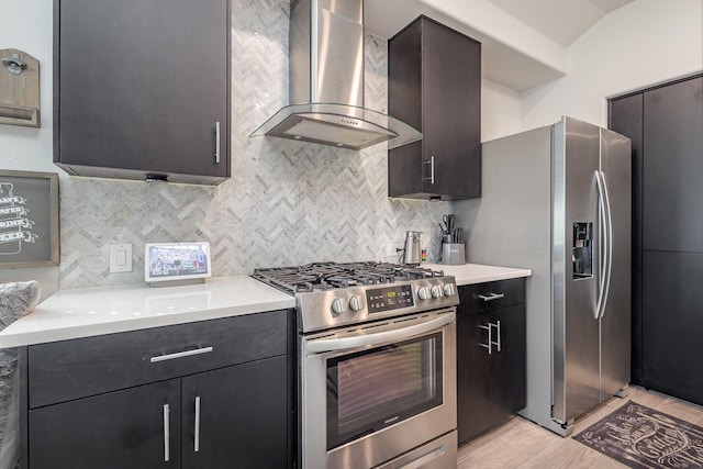 kitchen featuring light countertops, appliances with stainless steel finishes, decorative backsplash, and wall chimney exhaust hood
