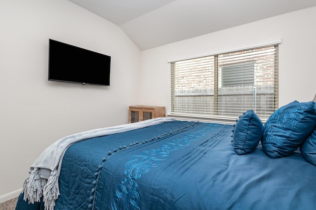 carpeted bedroom featuring baseboards and lofted ceiling