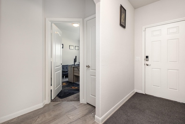 hall with baseboards and wood finished floors