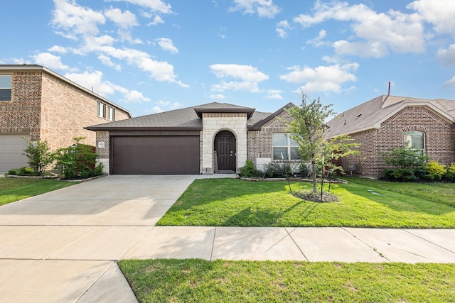 view of front of property with an attached garage, a front yard, driveway, and stone siding