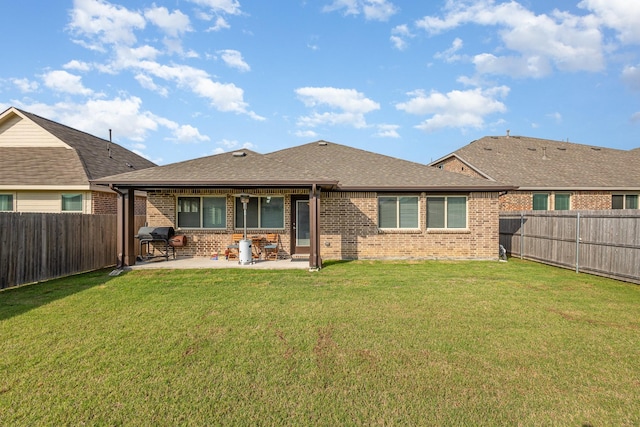 back of property with a fenced backyard, a patio area, and brick siding
