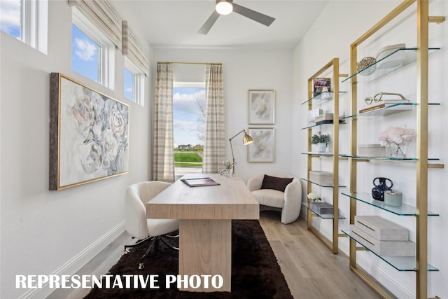 office space featuring baseboards, wood finished floors, and a ceiling fan