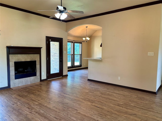 207 Shary St, Aledo, TX 76008 - unfurnished living room with baseboards, arched walkways, ornamental molding, wood finished floors, and ceiling fan with notable chandelier
