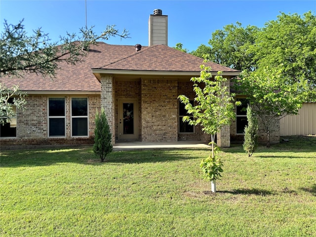 207 Shary St, Aledo, TX 76008 - back of property featuring a chimney, a patio area, roof with shingles, a yard, and brick siding
