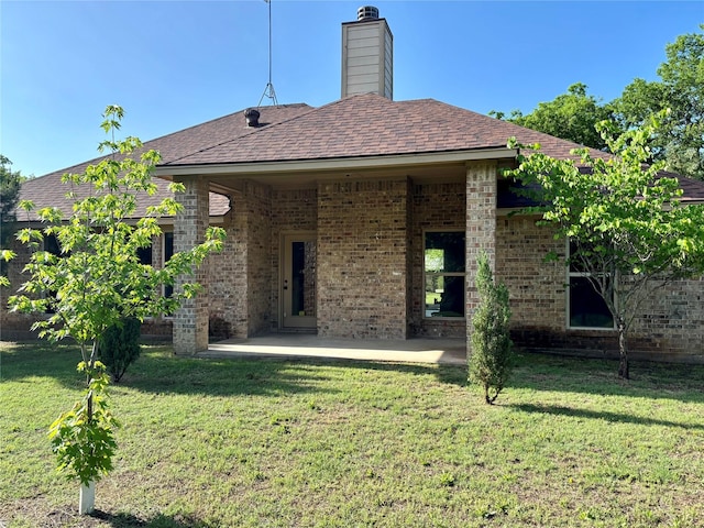 207 Shary St, Aledo, TX 76008 - back of house featuring a shingled roof, a patio area, brick siding, a yard, and a chimney