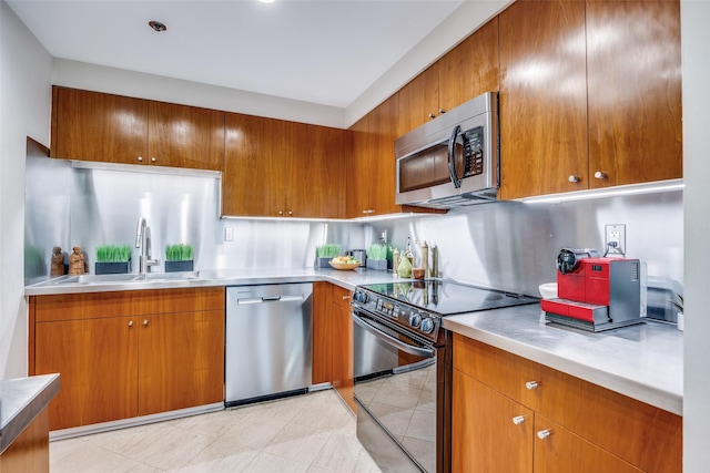 3030 Mckinney Ave Unit 1804, Dallas, TX 75204 - kitchen with stainless steel appliances, a sink, brown cabinetry, stainless steel countertops, and modern cabinets