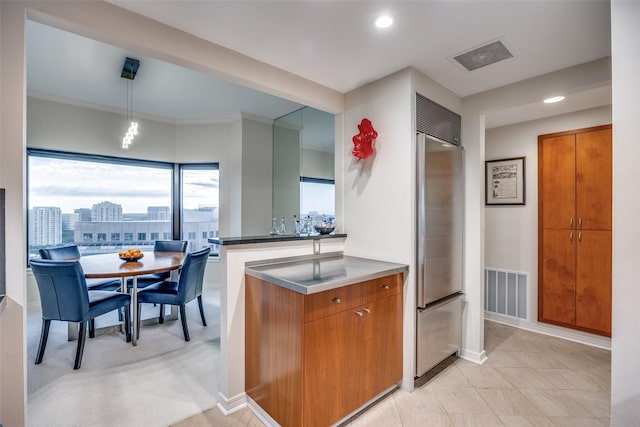 3030 Mckinney Ave Unit 1804, Dallas, TX 75204 - kitchen featuring stainless steel counters, built in refrigerator, brown cabinets, recessed lighting, and decorative light fixtures