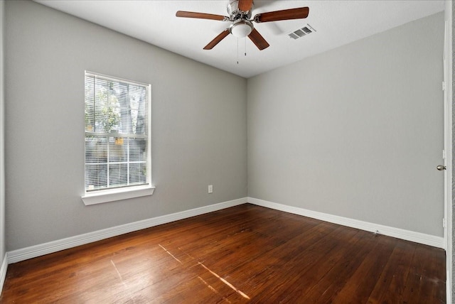 unfurnished room featuring dark wood-type flooring, visible vents, ceiling fan, and baseboards