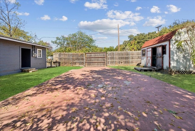 view of patio with fence, a storage unit, and an outbuilding