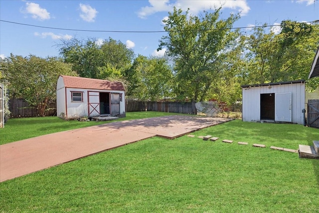 view of yard featuring a storage shed, an outdoor structure, and a fenced backyard
