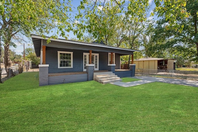 bungalow-style house with covered porch, fence, and a front yard