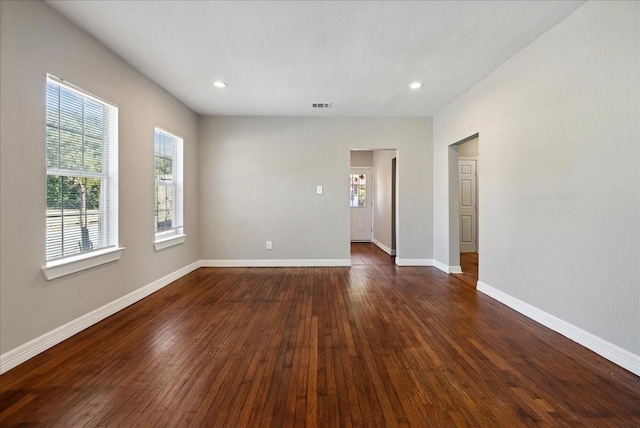 spare room featuring visible vents, recessed lighting, dark wood-style floors, and baseboards