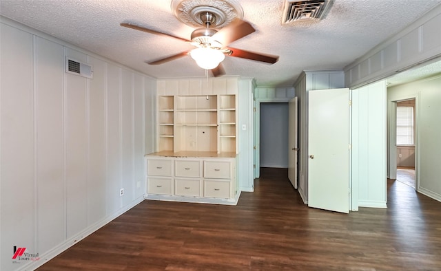 unfurnished bedroom featuring dark wood-style floors, a textured ceiling, and visible vents