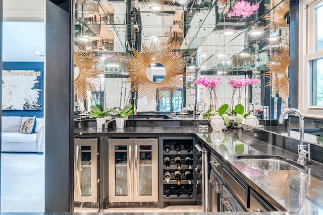 bar with beverage cooler, a sink, and indoor wet bar