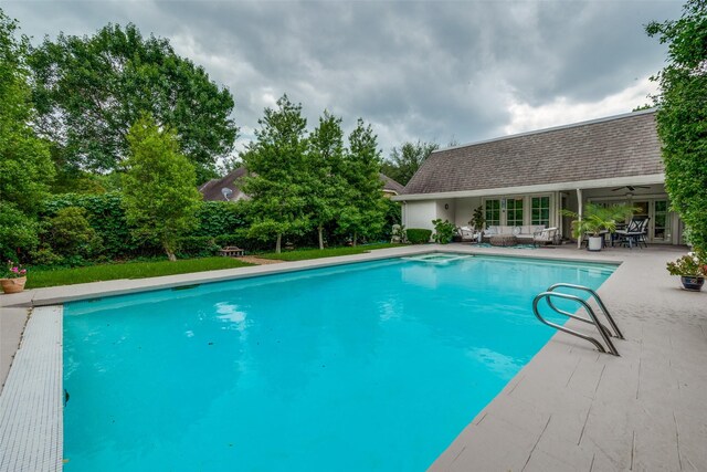 outdoor pool with french doors and a patio area