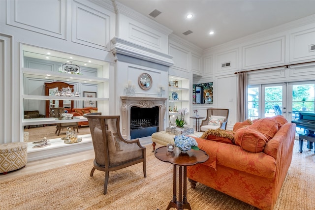 living room featuring built in shelves, french doors, recessed lighting, a high end fireplace, and visible vents
