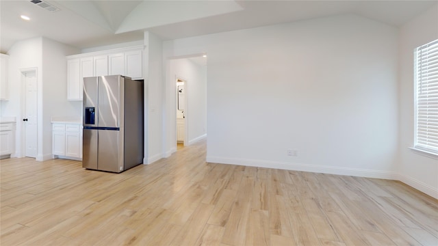 338 S 3rd St, Jacksboro, TX 76458 - kitchen with stainless steel fridge with ice dispenser, light countertops, white cabinets, light wood finished floors, and visible vents