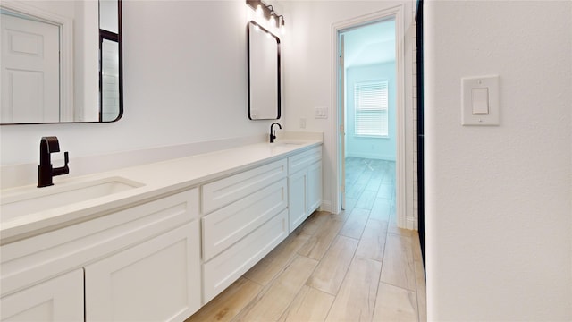 338 S 3rd St, Jacksboro, TX 76458 - full bath with wood finish floors, double vanity, a sink, and baseboards