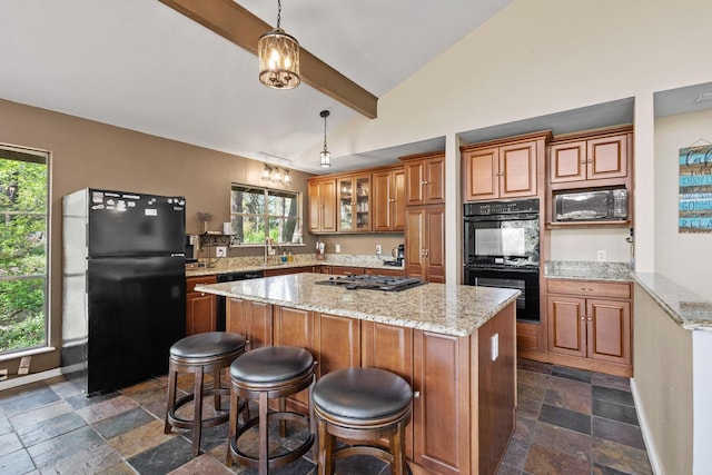 kitchen with stone tile flooring, lofted ceiling with beams, brown cabinetry, a center island, and black appliances