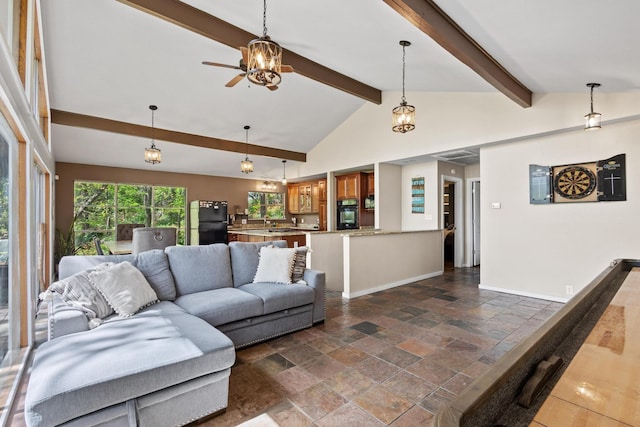 living area with baseboards, vaulted ceiling with beams, a ceiling fan, and stone tile flooring