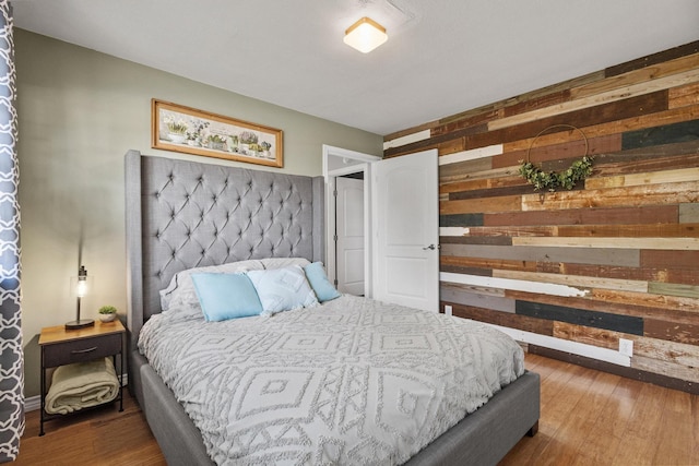 bedroom with wooden walls and wood finished floors