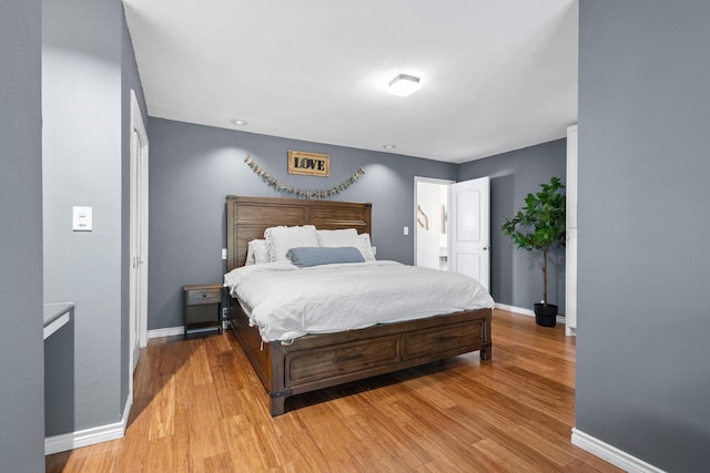 bedroom with light wood-type flooring and baseboards