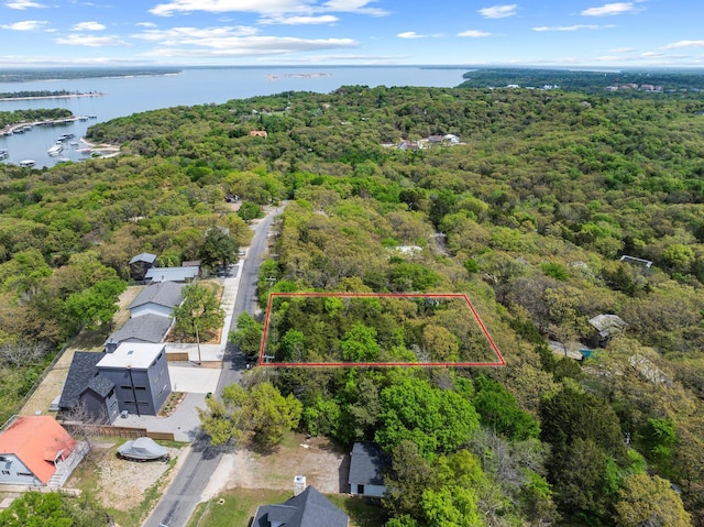 aerial view featuring a wooded view and a water view