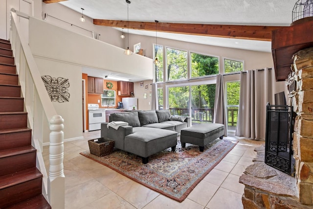 living area featuring light tile patterned floors, stairway, beam ceiling, a fireplace, and high vaulted ceiling