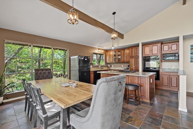 dining room featuring stone tile floors, high vaulted ceiling, and baseboards