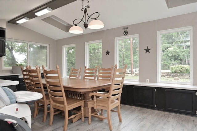 dining space with light wood finished floors and lofted ceiling