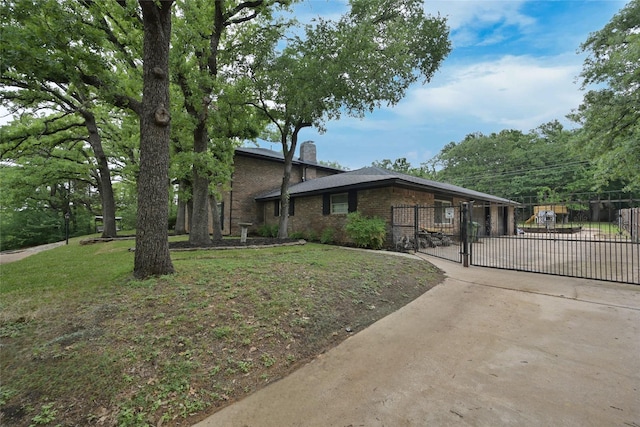 view of front of house with a chimney, a gate, driveway, brick siding, and an attached garage