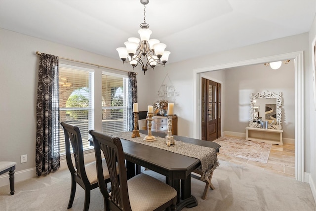 dining space with baseboards, an inviting chandelier, and light colored carpet