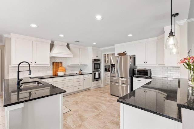kitchen featuring a sink, decorative backsplash, a peninsula, premium range hood, and appliances with stainless steel finishes