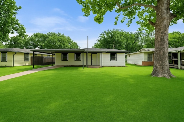 view of front of home featuring fence, an attached carport, and a front yard