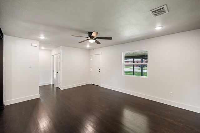 empty room featuring visible vents, dark wood-style flooring, ceiling fan, and baseboards