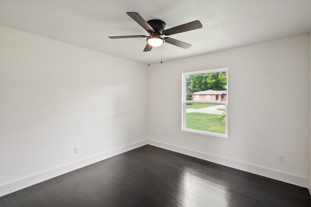 spare room featuring baseboards, ceiling fan, and dark wood-style floors
